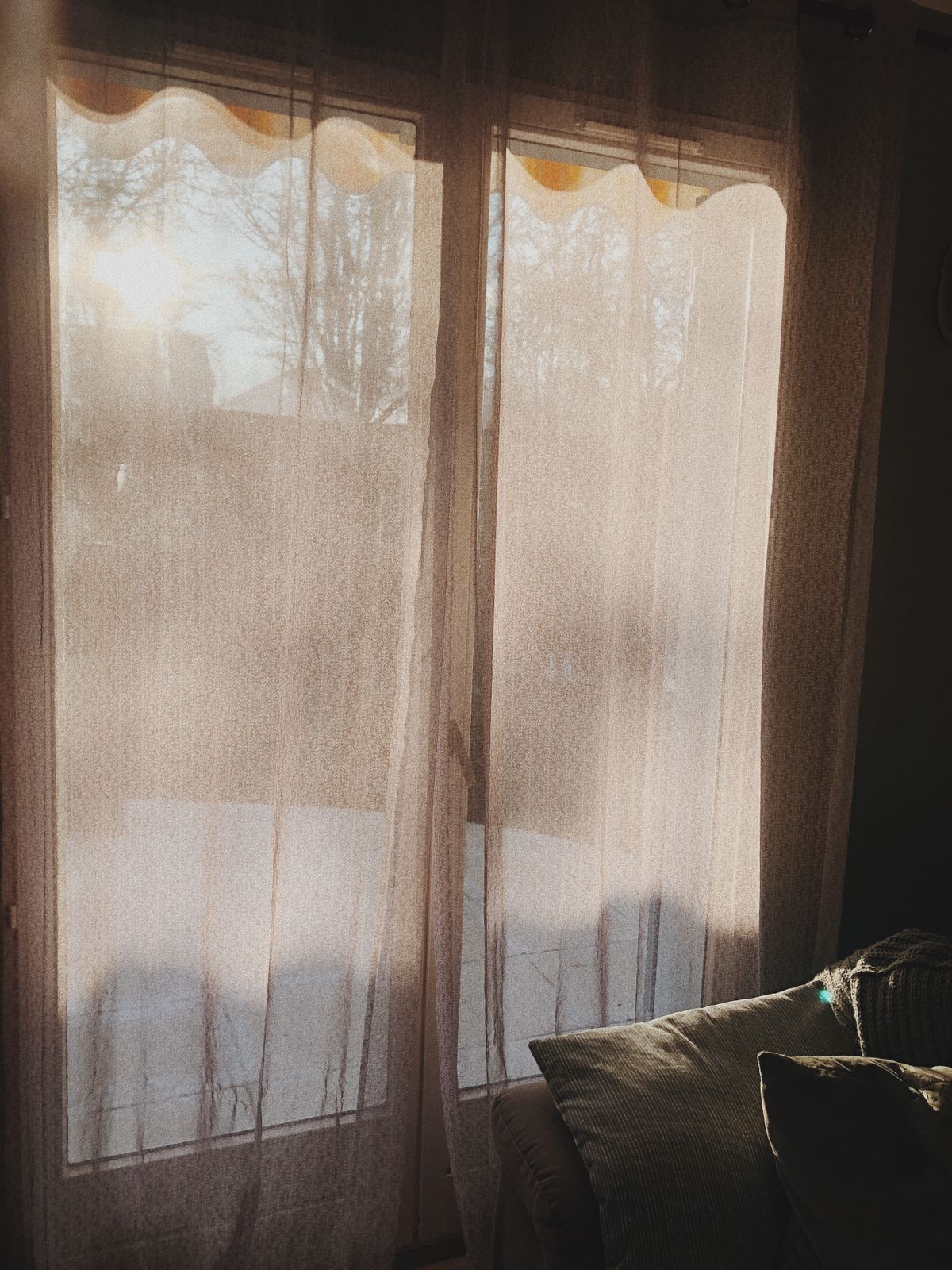 Helle Gardine vor einem sonnigen Fenster
